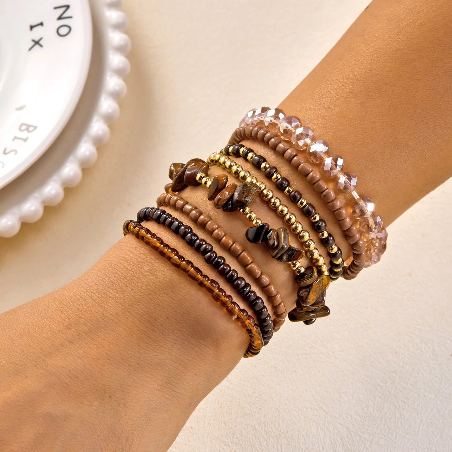Set of 10 bohemian wood beaded bracelets by MAIRA'S COLLECTIONS with natural wood beads and boho-style designs.