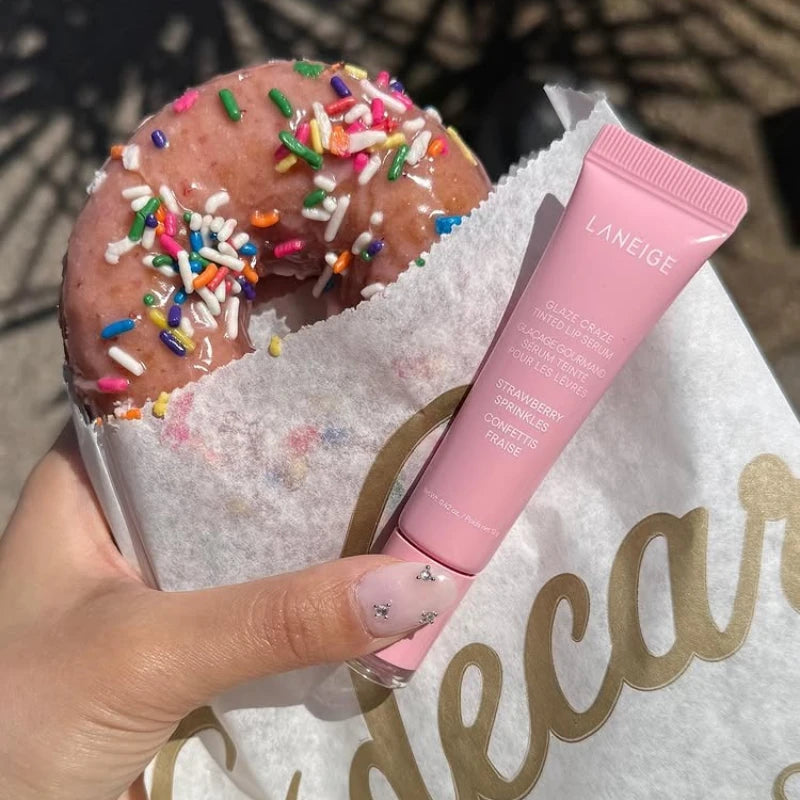 MAIRA'S COLLECTIONS Donut Lip Oil with strawberry, raspberry, and chocolate scent, featuring a colorful donut-shaped lip balm.