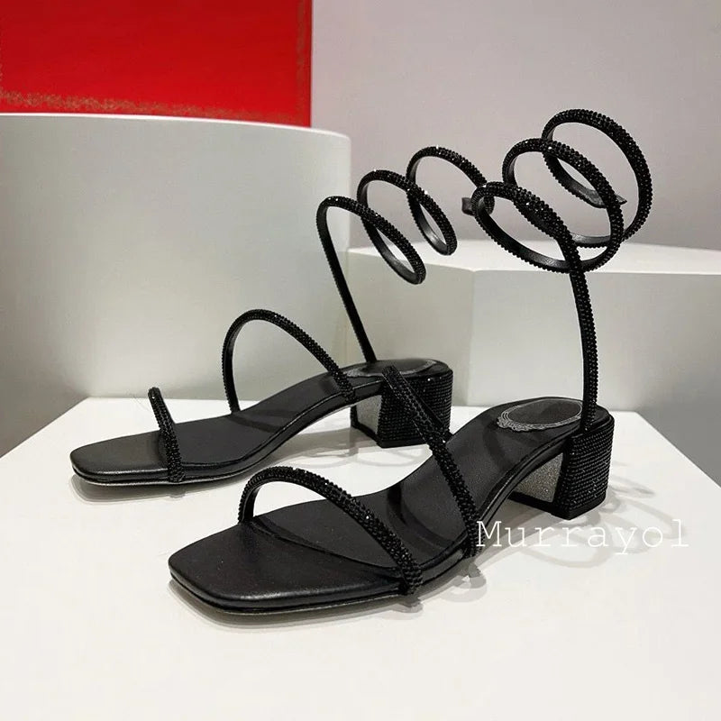 Women's rhinestone square heel sandals with elastic ankle strap by MAIRA'S COLLECTIONS, showcasing sparkling details and stylish design.