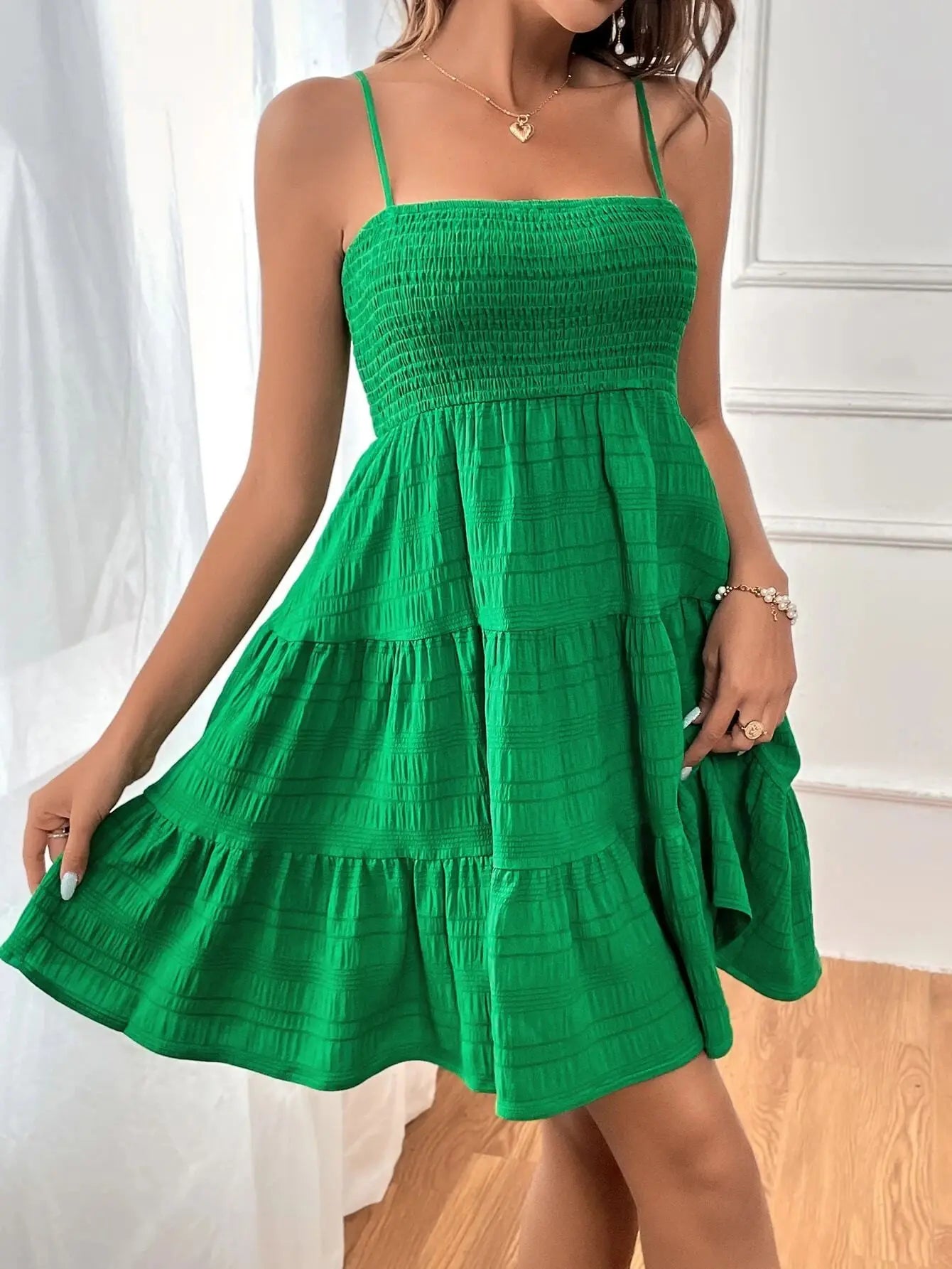 Women's smocked mini dress by MAIRA'S COLLECTIONS featuring a fitted bodice and flowy skirt, shown on a model.