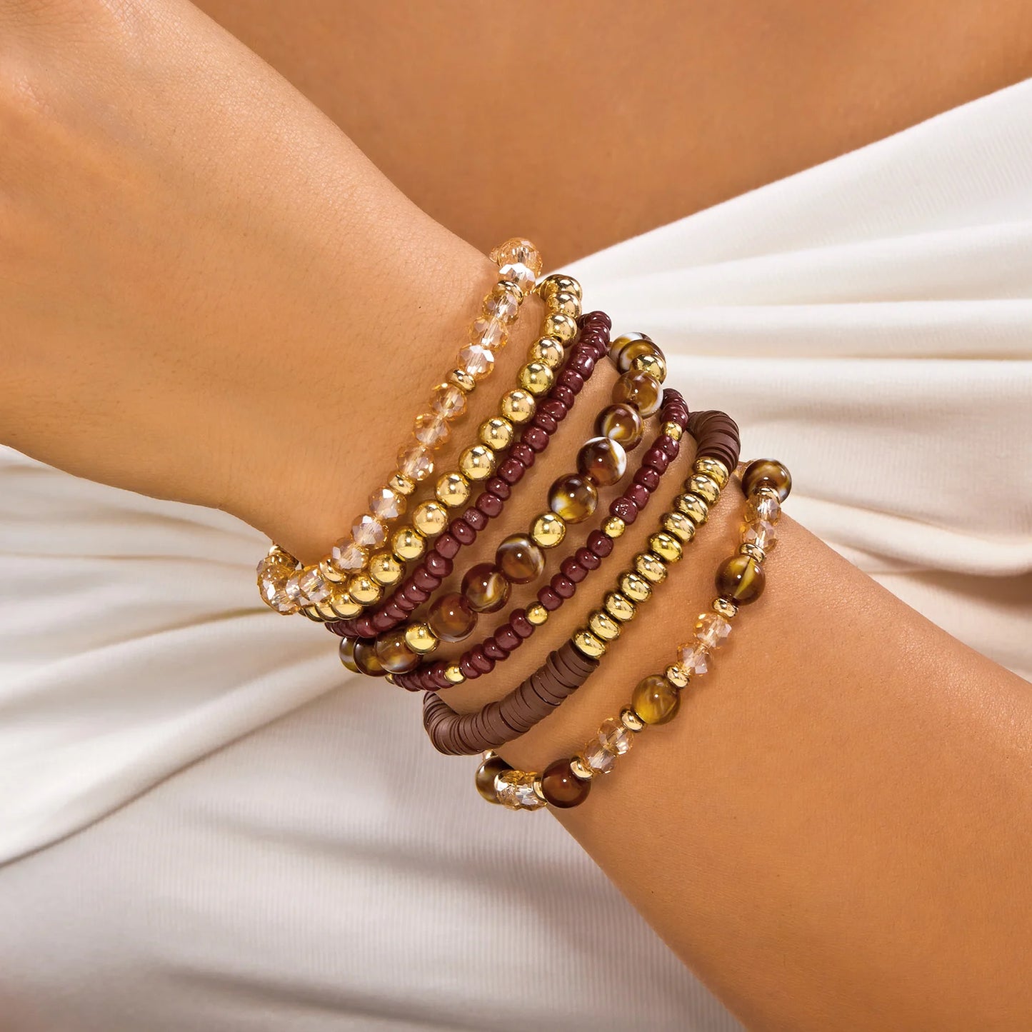 Set of 10 bohemian wood beaded bracelets from MAIRA'S COLLECTIONS displayed together, featuring natural wooden beads and earthy tones.