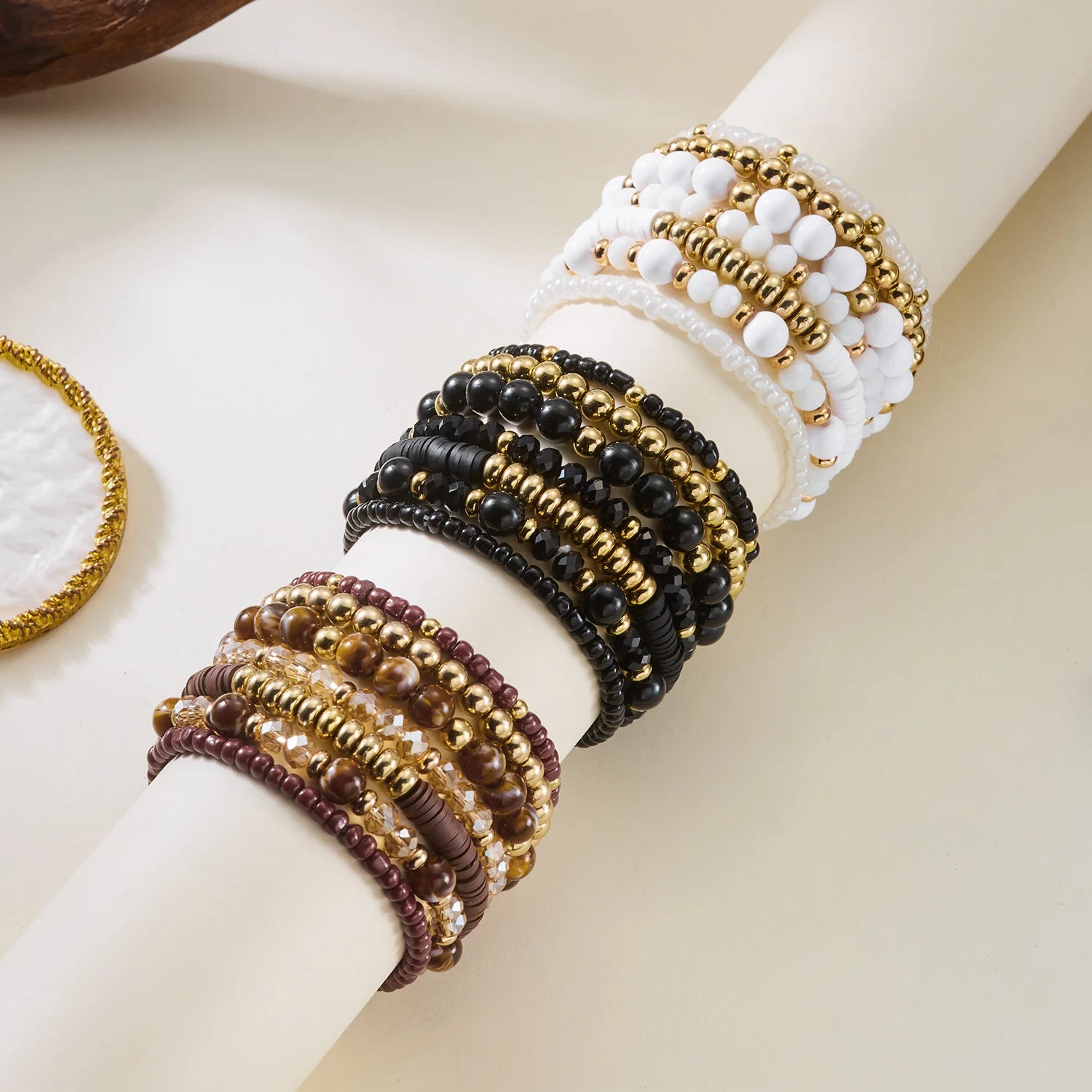 Set of 10 bohemian wooden beaded bracelets from MAIRA'S COLLECTIONS displayed together on a neutral background.
