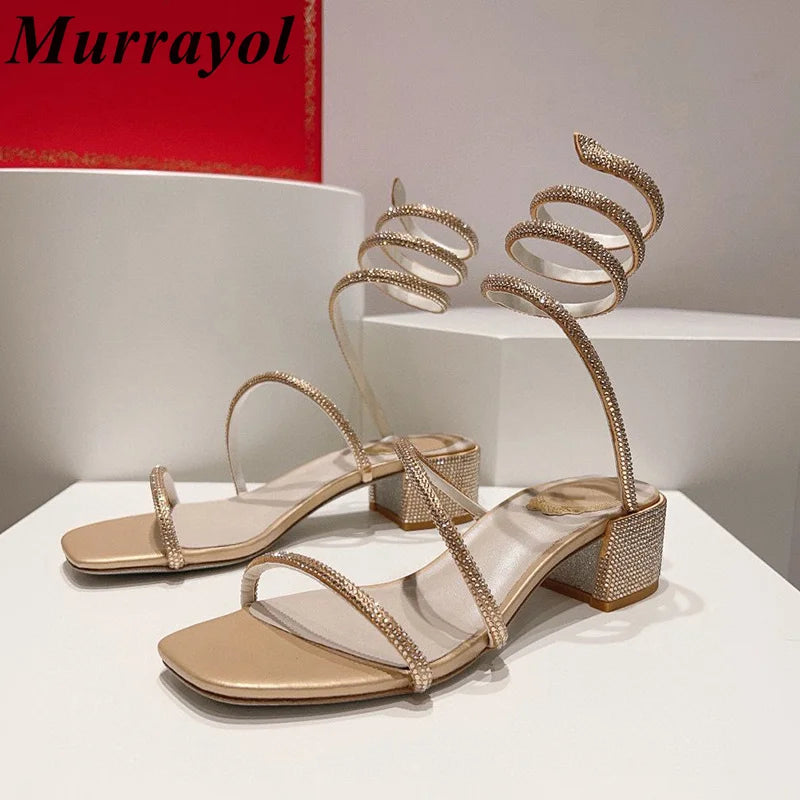 Women's rhinestone square heel sandals with elastic ankle strap by MAIRA'S COLLECTIONS, featuring shiny rhinestone details and stylish design.